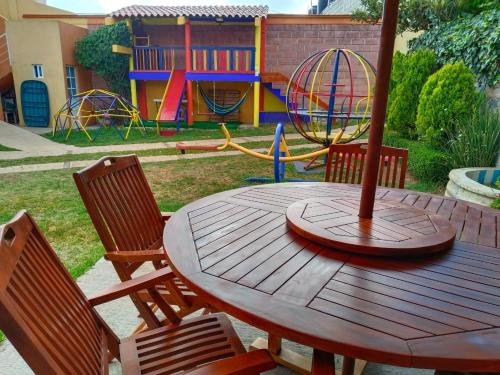 a wooden table with chairs and a playground at Casa Granada Jilotepec in Jilotepec