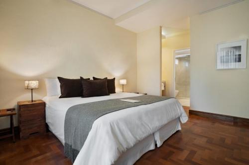 a bedroom with a large white bed and a window at Terrazas de los Andes Guest House in Ciudad Lujan de Cuyo