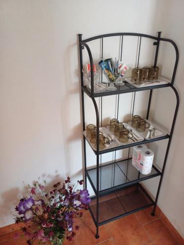 a shelf with a vase of flowers next to a wall at Penzion U Mnicha in Vilémov