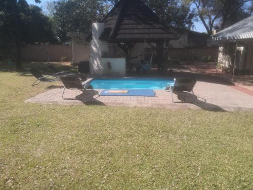 a swimming pool with a fountain in a yard at 15 On Reitz Bela bela in Bela-Bela
