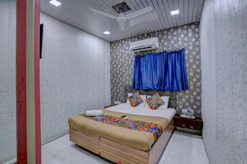 a bedroom with two beds and a blue window at Hotel Saini,Mumbai in Mumbai