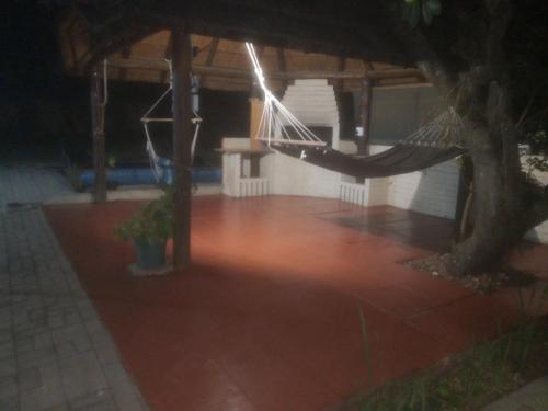 a porch with a hammock and a tree at night at 15 On Reitz Bela bela in Bela-Bela