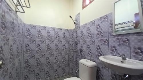 un baño con inodoro y lavabo en Benedict Guesthouse by Mori Hospitality, en Labuan Bajo