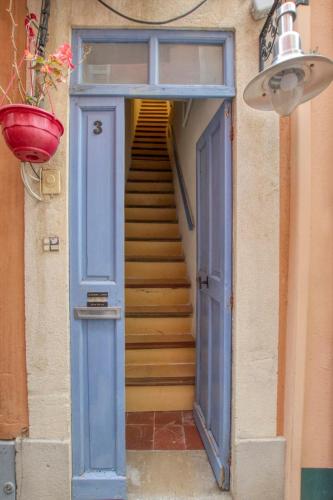 un escalier avec une porte bleue et un escalier dans l'établissement Charming apartment in the city center, à Sanary-sur-Mer
