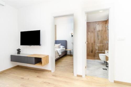 a living room with a television and a bathroom at Ema'ar Villas in Ulcinj