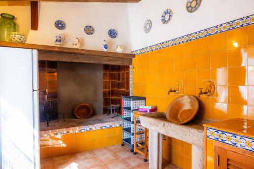 a kitchen with orange tiled walls and a sink at Sa Casa des Pintor Miquel Vives 213 in Cala Bona