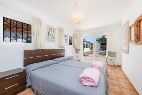 um quarto com uma cama com toalhas cor-de-rosa em Sa Casa des Pintor Miquel Vives 213 em Cala Bona