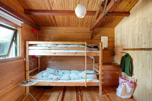 - une chambre avec des lits superposés dans une cabane en bois dans l'établissement Classic Danish Summerhouse Experience 250m From The Sea, à Liseleje
