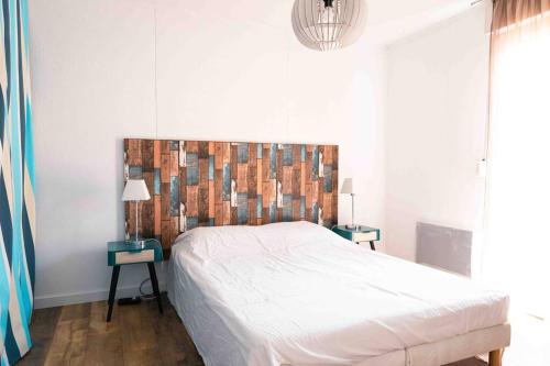 une chambre avec un grand lit avec une tête de lit en bois dans l'établissement Villa T3 Soustons-Plage Vieux-Boucau, à Soustons