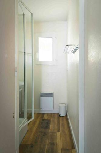 La salle de bains est pourvue d'un miroir et de parquet. dans l'établissement Villa T3 Soustons-Plage Vieux-Boucau, à Soustons