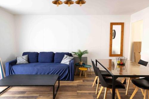 un salon avec un canapé bleu et une table dans l'établissement Villa T3 Soustons-Plage Vieux-Boucau, à Soustons