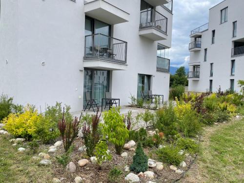 an apartment building with a garden in front of it at Apartmán Victory Port in Liptovský Mikuláš