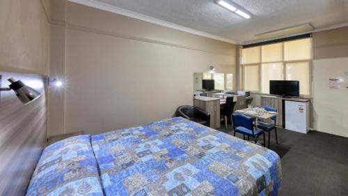 a bedroom with a bed and a table and chairs at Comfort Inn Crystal Broken Hill in Broken Hill