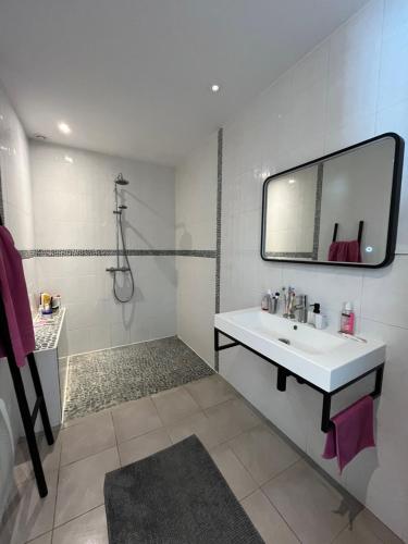 a white bathroom with a sink and a mirror at Villa piscine confort cosy in Brouilla