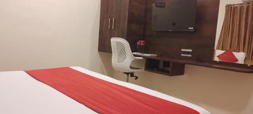 a room with a bed and a chair and a desk at Shine Hospitality Palace in Mumbai