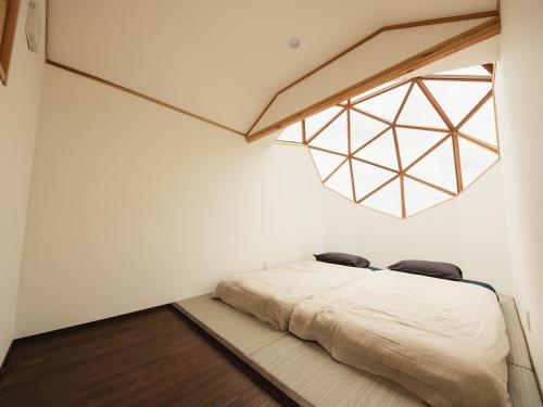 1 dormitorio con 1 cama en el suelo de madera en Hole 37, en Tsukuba