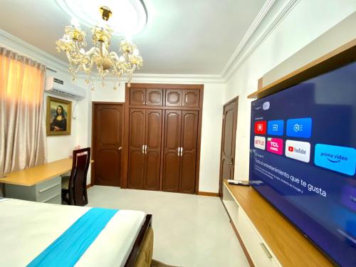 una camera con letto, TV e scrivania di Big House a Guayaquil