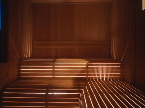 a wooden bench in a room with light shining on it at Hole 37 in Tsukuba