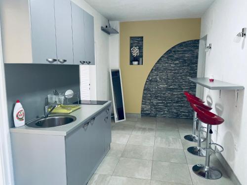 cocina con fregadero y pared de ladrillo en Apartmani Kotor Varoš, en Donja Varoš