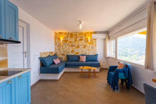a living room with a blue couch and a window at The Life Suites in Limnionas
