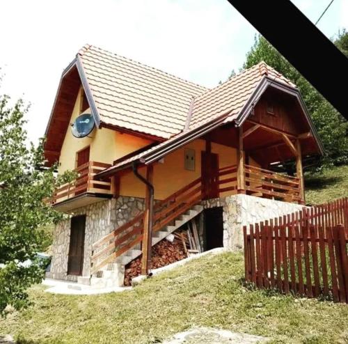 une maison avec un toit en bois et une clôture dans l'établissement Vila Mitrović, à Bajina Bašta
