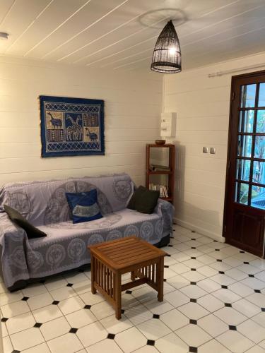 a living room with a couch and a coffee table at Baobab et Palmiers in Étang-Salé