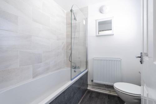 y baño blanco con aseo y ducha. en Free Parking Good Location Near Cleethorpes Beach en Grimsby