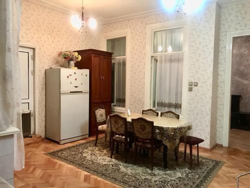 a kitchen with a table and chairs and a refrigerator at Cozy, large apartment in the heart of city center in Baku