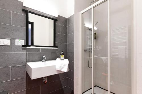 a bathroom with a sink and a shower at Hôtel Le Loft in Trie sur Baise