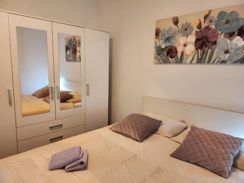 een slaapkamer met een bed en een kast met een spiegel bij Apartment Bike Corner in Zadar