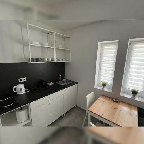 a kitchen with white cabinets and a wooden table at Apartmán Markéta in Lipno nad Vltavou