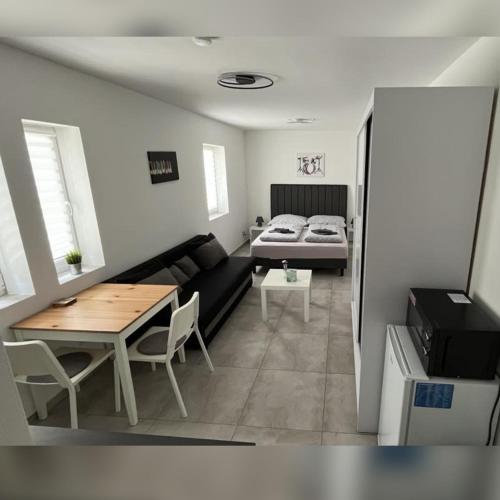 a living room with a couch and a table and a bed at Apartmán Markéta in Lipno nad Vltavou