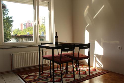 uma mesa de jantar com 2 cadeiras e uma garrafa de vinho em Šiška Deluxe em Ljubljana
