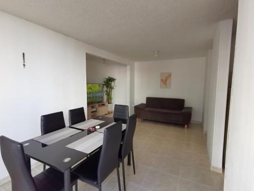 a dining room with a table and chairs and a couch at Mi hogar - Apartamento familiar en Bucaramanga in Bucaramanga