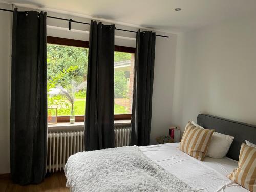 a bedroom with a bed and a large window at Deich Quartier 9.3 in Dorum Neufeld