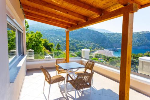 a balcony with a table and chairs and a view at The Life Suites in Limniónas