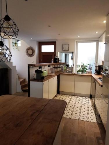 uma grande cozinha com uma mesa num quarto em Maison hypercentre calme, terrasse, garage, poêle em Clermont-Ferrand