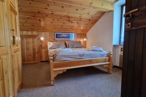 a bedroom with a bed in a wooden room at Le Grenier du Géant cir vda 0191 in Courmayeur