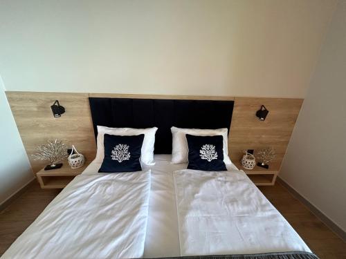 a bedroom with a large bed with two pillows at Lago Apartamenty Domki in Niesulice