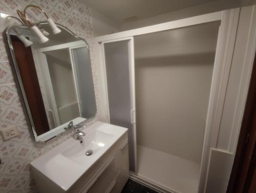uma casa de banho com um lavatório, um chuveiro e um espelho. em apartamento centro em Vitoria-Gasteiz