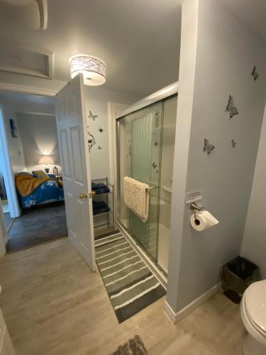 a bathroom with a shower and a toilet and a bed at Ingonish Loft in Ingonish