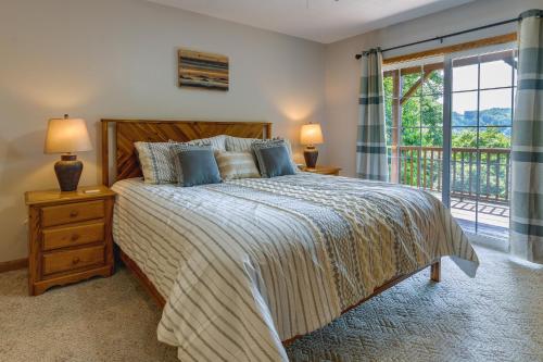 a bedroom with a large bed and a balcony at Mtn-View Escape with Hot Tub, 9 Mi to Skiing! in Maggie Valley