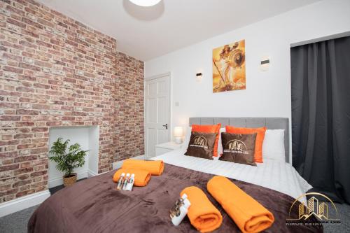 - une chambre dotée d'un mur en briques et d'un lit avec des oreillers orange dans l'établissement Athena Apartment - The Wisdom of Town, à Southampton