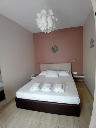 a bedroom with a large white bed with a chandelier at Beauty Thessaloniki Apartment in Thessaloniki