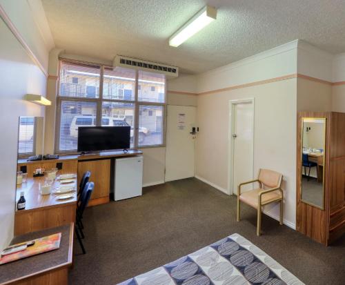 a room with a bed and a desk and a chair at Comfort Inn Crystal Broken Hill in Broken Hill