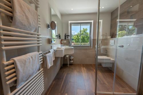 La salle de bains est pourvue d'une douche, d'un lavabo et d'un miroir. dans l'établissement ChiemseeStern Vacation & Recreation "Adults Only", à Gstadt am Chiemsee