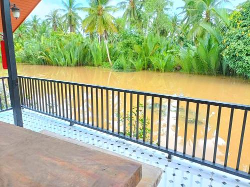 a balcony with a view of a body of water at Amantra homestay & village in Suratthani