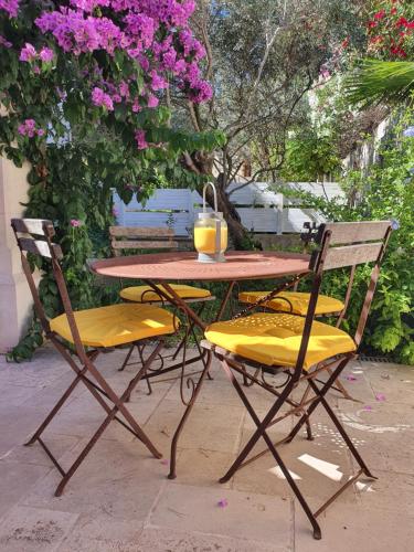 une table et deux chaises avec une table et des fleurs dans l'établissement Gîte le Félibre, à Châteauneuf-les-Martigues