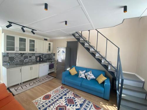 a living room with a blue couch and a staircase at DENİZE 5 DAKİKA VE DOĞA EVİ in Cesme