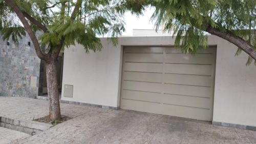 a garage door with a tree next to a building at Orfila Apart 1 in Mendoza